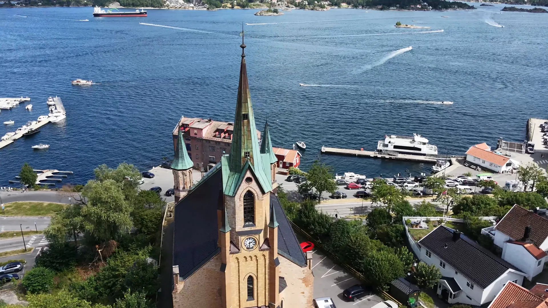 The church tower and spires from above, with the harbour and boats behind