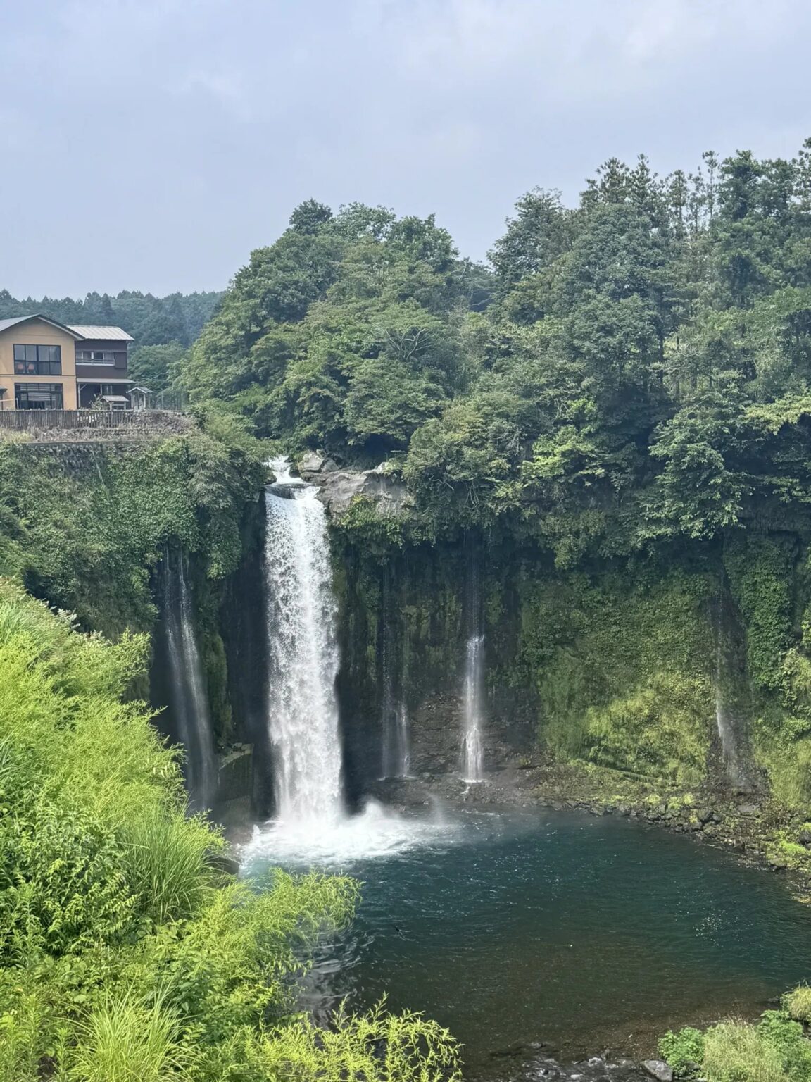 Otodome Falls dropping into a deep green pool, surrounded by forest